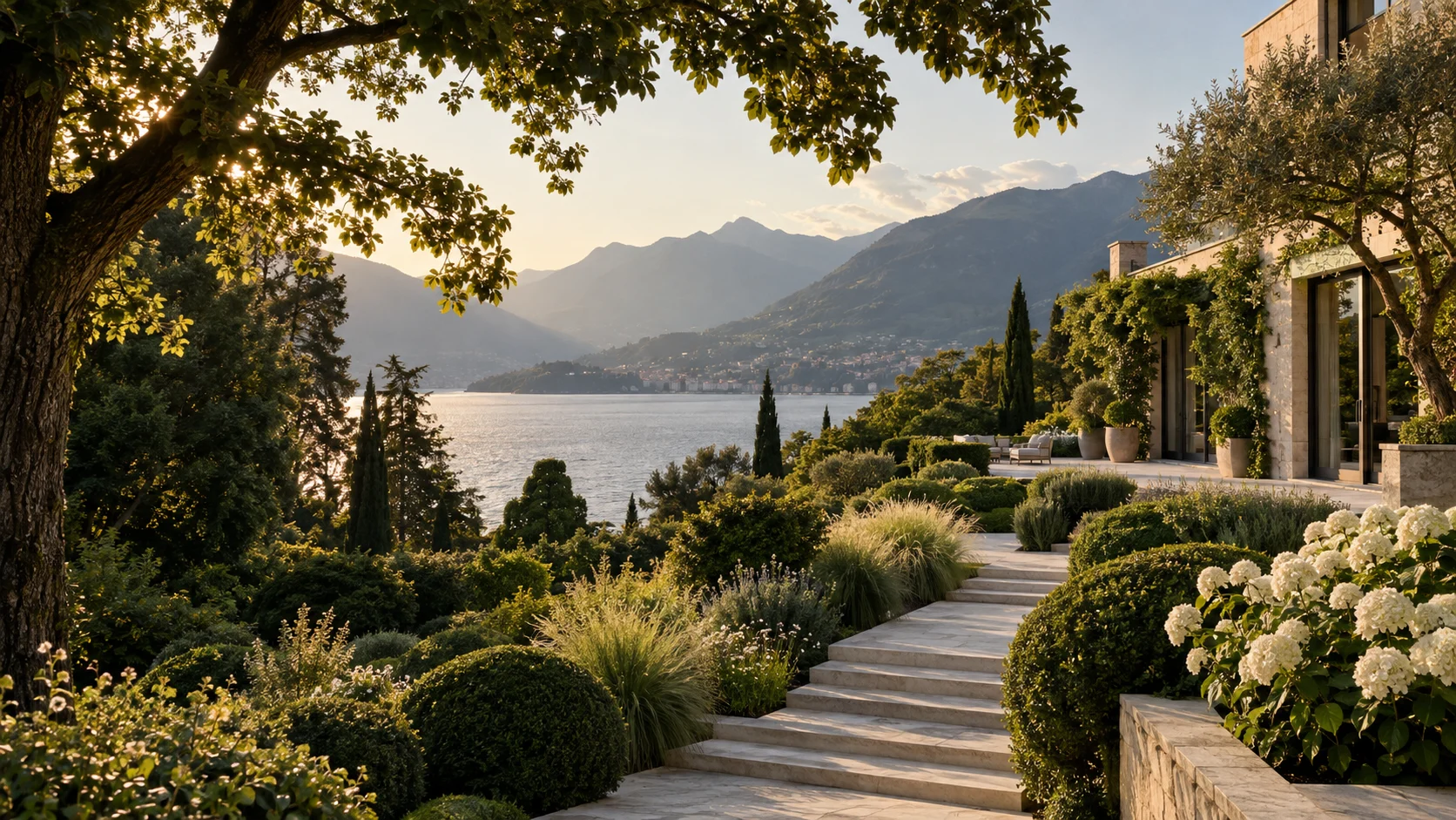 A lush estate garden with limestone steps overlooking a lake